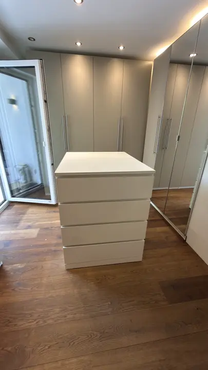 Kleiderschrank mit Spiegeltüren neben einer passenden Kommode.
