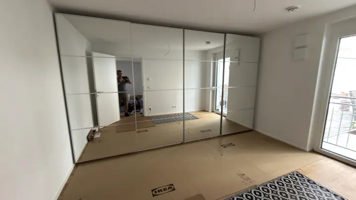 Großer Kleiderschrank mit raumhohen Spiegelschiebetüren.