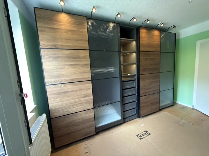 PAX Schiebetürenschrank mit Holz- und Glaselementen.