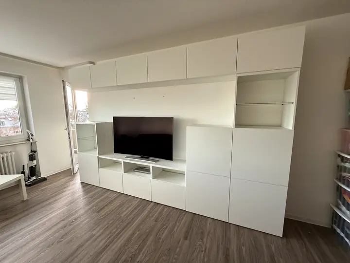 Weiße Wohnwand mit integriertem Platz für den Fernseher.